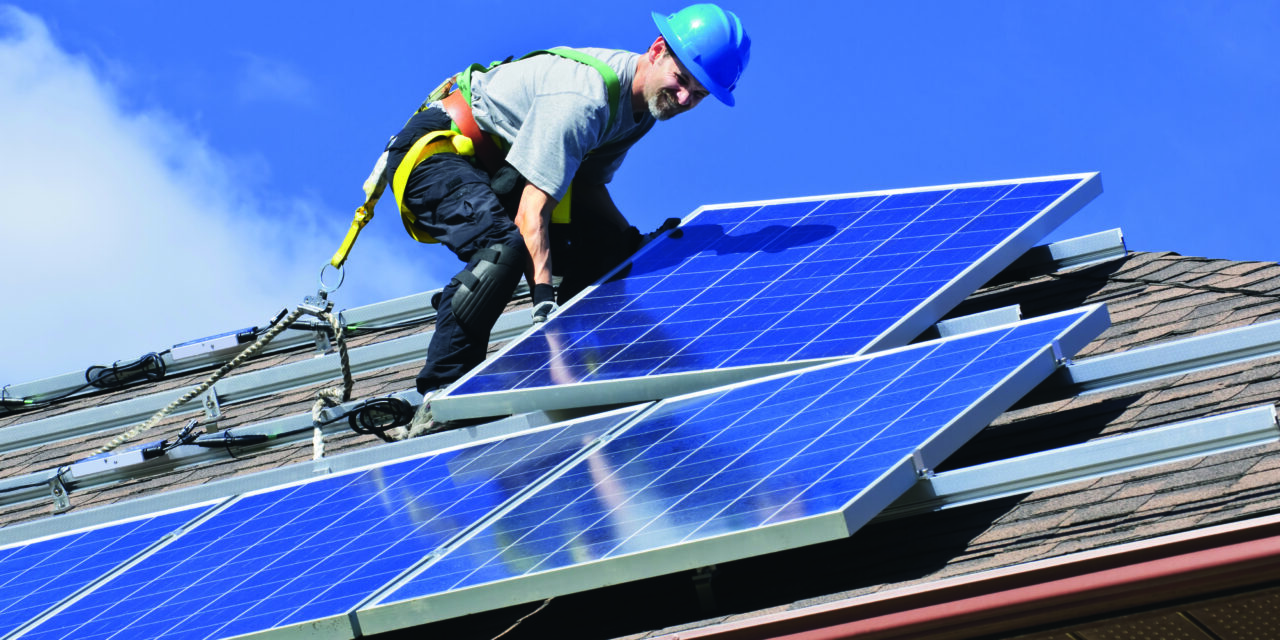 Man,Installing,Alternative,Energy,Photovoltaic,Solar,Panels,On,Roof